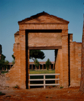 [Brick entrance gate with open space behind.]
